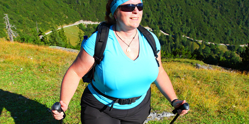 A woman hiking in green mountains. 