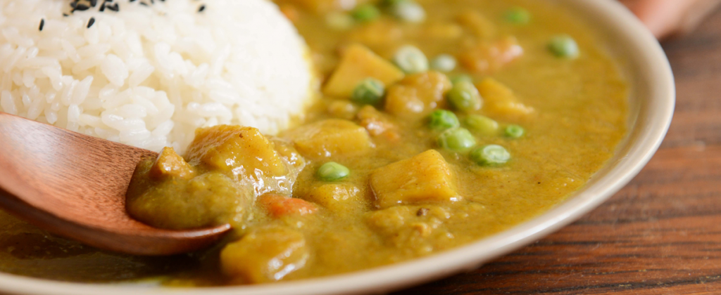 Close up of a bowl of curry with white rice.