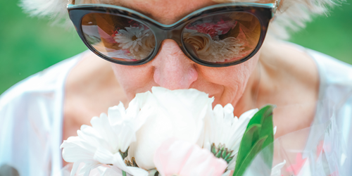 Close up of a woman smelling a fresh flower